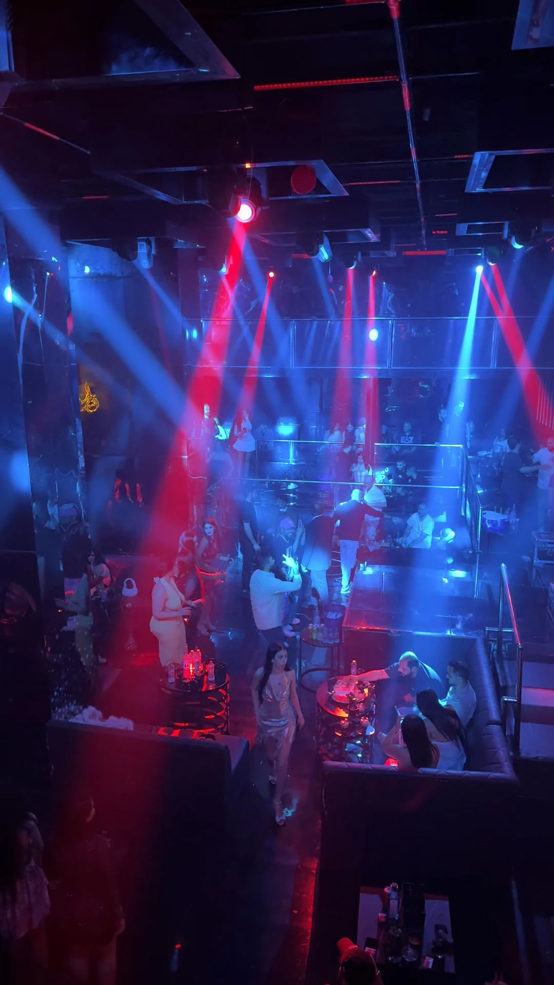 High-angle view of the main room dancefloor and VIP banquettes bathed in blue and red spotlights at XOXO Nightclub & Lounge Dubai