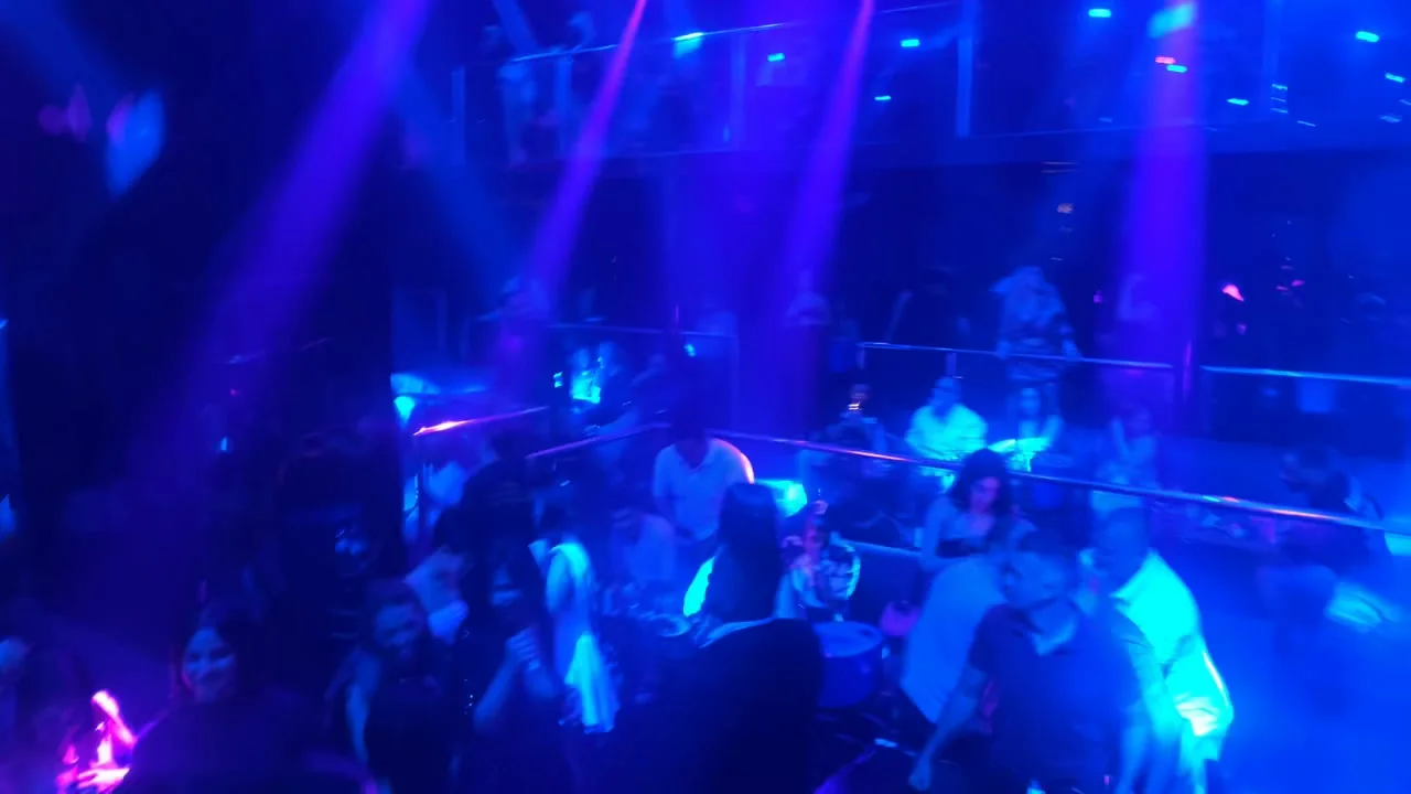 Packed dancefloor crowd moving under immersive blue club lighting at XOXO Nightclub & Lounge Dubai