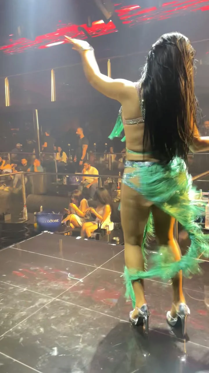 Stage dancer in sparkling emerald fringes performing before VIP tables and guests at XOXO Nightclub & Lounge Dubai