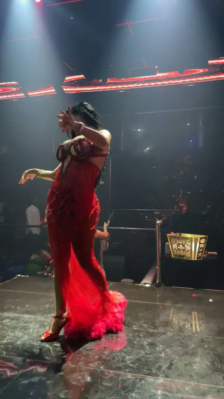 Live dancer in crimson gown performing on the polished stage under focused spotlights at XOXO Nightclub & Lounge Dubai